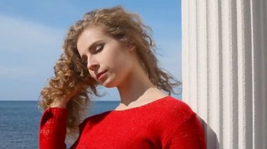 Kadın çalışan el sahilde deniz rüzgarda üfleme kıvırcık saçlarının arasından portresi kapatın. Mavi gökyüzü üzerinde mutlu erkek.