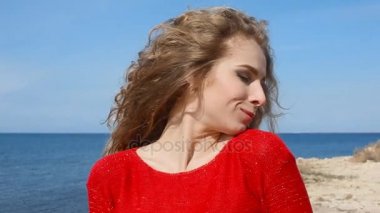 Kadın çalışan el sahilde deniz rüzgarda üfleme kıvırcık saçlarının arasından portresi kapatın. Mavi gökyüzü üzerinde mutlu erkek