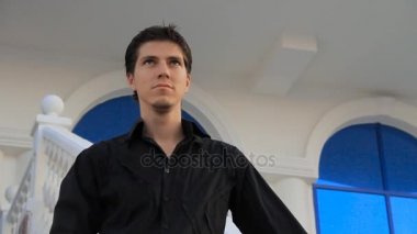 Yakışıklı genç adamın şık saç modeli açık havada dikey, adam kameraya poz ile yakın çekim.