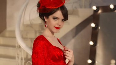 Retro şapka ve kırmızı elbise genç kız güzel moda portre, esmer modeli ile kırmızı dudaklar makyaj, zarif saç modeli, kolye kadınlar tarafından ayna soyunma makyaj için ampuller ile poz Takı Seti