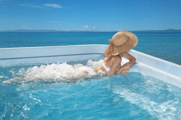 Γυναίκα στην παραλία απολαμβάνοντας καπέλο στο τζακούζι, πισίνα Tropica — Φωτογραφία Αρχείου