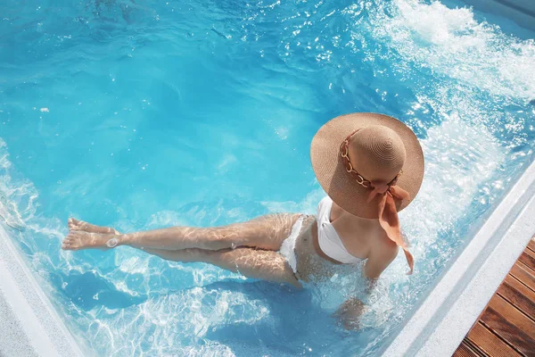 Γυναίκα στην παραλία καπέλο απολαμβάνοντας στην πισίνα σε τροπικό θέρετρο. — Φωτογραφία Αρχείου