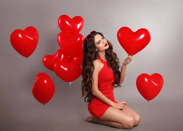 Linda chica morena en rojo con globos de corazón posando isol — Foto de Stock