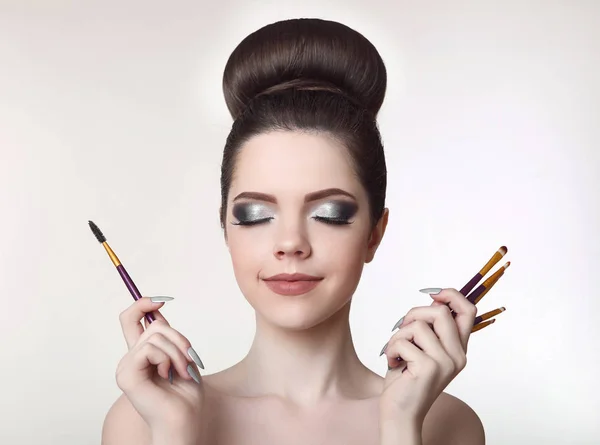 Artista de maquillaje. Bastante adolescente chica con lindo moño peinado y fash — Foto de Stock