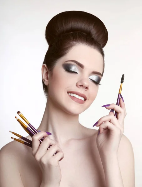Make-up artiest. Mooie tiener meisje met schattige broodje kapsel en fash — Stockfoto