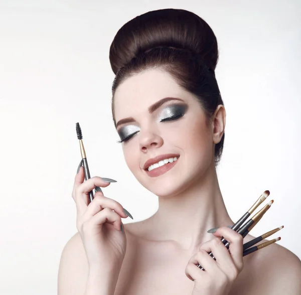 Make-up artiest. Mooie tiener meisje met schattige broodje kapsel en fash — Stockfoto
