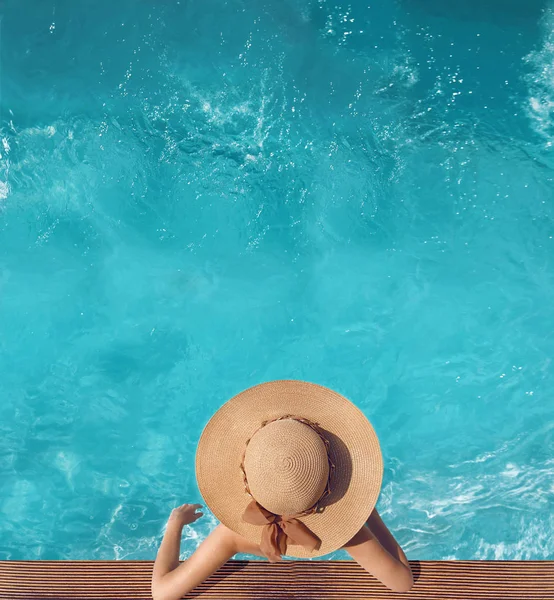Zadní pohled na ženy v slamák relaxaci v bazénu s vodou — Stock fotografie