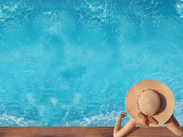 顶视图的女人在游泳池在芦墟中放松的草帽 — 图库照片