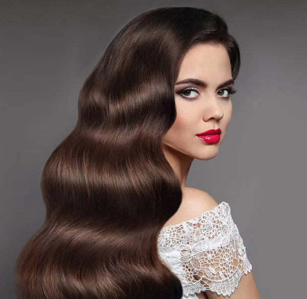 Pelo ondulado. Belleza morena labios rojos maquillaje y larga espinilla saludable — Foto de Stock