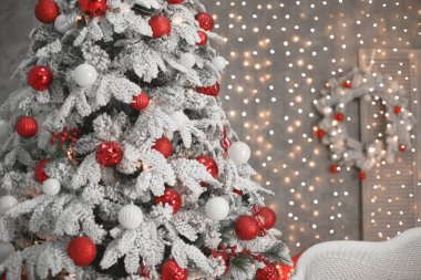 Bokeh ışıklar ve wrea önce kırmızı hediyeler ile karlı Noel ağacı