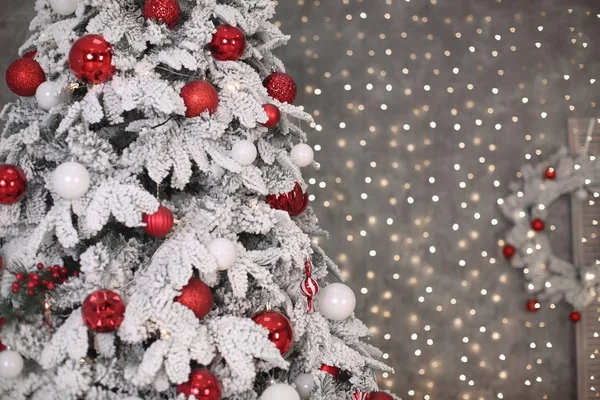 Χιονισμένο χριστουγεννιάτικο δέντρο με κόκκινο δώρα πριν bokeh φώτα και wrea — Φωτογραφία Αρχείου
