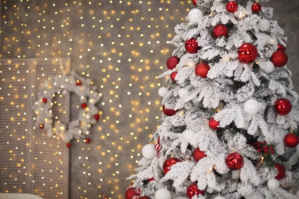 Havas karácsonyfa előtt bokeh fény és a piros ajándék díszítéssel — Stock Fotó