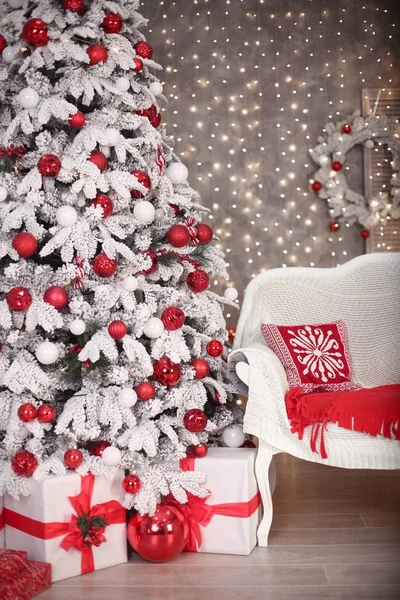 Albero di Natale innevato con regali rossi prima delle luci bokeh e wrea — Foto Stock