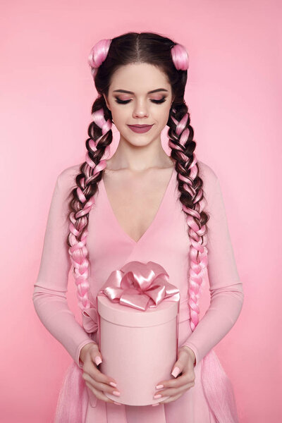 Красивая красивая девушка-подросток подарок коробку с луком над розовым s
