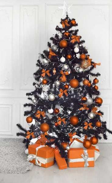 Árbol de Navidad con decoración de regalos de pelota antes de pared blanca en h —  Fotos de Stock