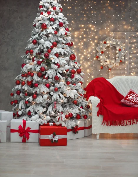 Árvore de Natal nevado com presentes vermelhos antes bokeh luzes e ureia — Fotografia de Stock