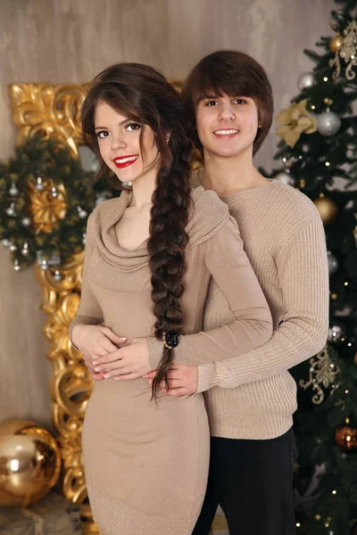 Retrato navideño de pareja adolescente joven abrazándose vistiendo de beige —  Fotos de Stock