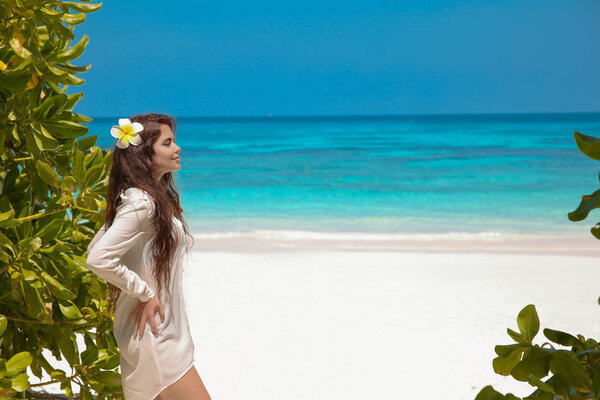 Beautiful free woman enjoying on exotic beach in summer by tropi