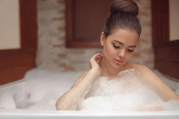 Mujer joven relajante en spa jacuzzi de espuma, morena disfrutando —  Fotos de Stock