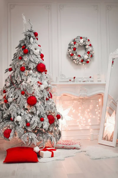 Рождественский интерьер и украшения. Снежное дерево украсили красными гирляндами — стоковое фото