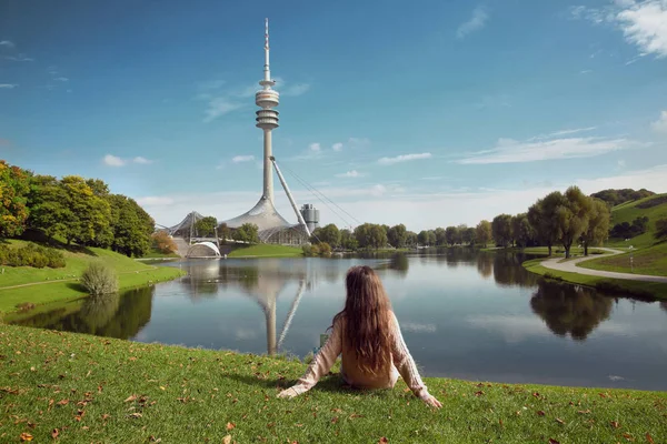Woman sightseeing in Olympiapark, Munich. Brunette sitting on th — Stock Photo, Image