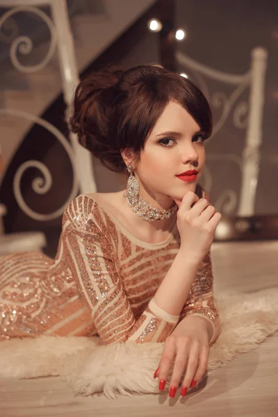 Modne młoda dziewczyna stwarzających w złotej sukni o studiach balu — Zdjęcie stockowe