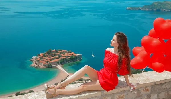 Romantická dívka v červených šatech nad ostrovem Sveti Stefan v Budvě, Mo — Stock fotografie