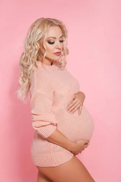 Беременная женщина, ожидающая ребенка, обнимает ее — стоковое фото