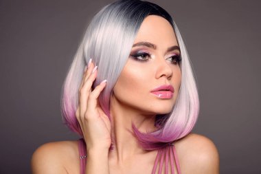 Ombre Bob kısa saçlı bir kadının güzel portresi. Güzel boyalı saçlar. Moda saç kesimi. Gri arka planda kısa, parlak saç kesimleri olan sarışın manken. Makyaj. Manikürlü tırnaklar.