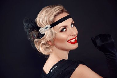 Retro kadın portresi. Sarı dalgalı saç stili. Hollywood kırmızı dudak makyajı. Kıvırcık saçlı. Siyah stüdyo arka planında izole edilmiş klasik elbiseli güzel bir kadın..