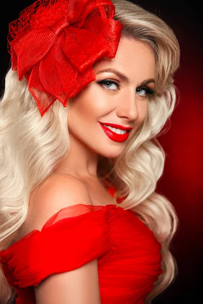 Elegant Woman with red lips and hat over dark background. Beautiful girl with curly hair surprised and smiling. Expressive facial expressions. Retro  blonde portrait.