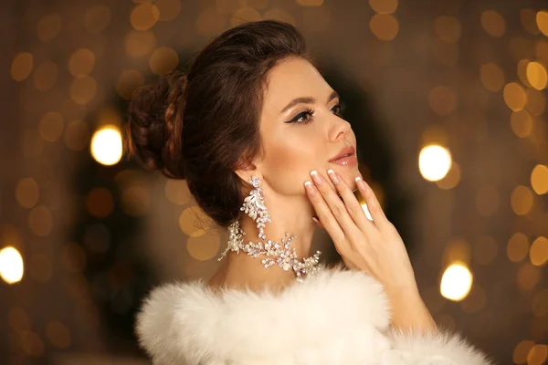 白い毛皮のエレガントな女性 ダイヤモンドイヤリングやネックレスジュエリーセットと若い美しい花嫁の冬のファッション肖像画 魅力的なブルネットとともに化粧と結婚式の髪のスタイル以上クリスマスBokeh — ストック写真