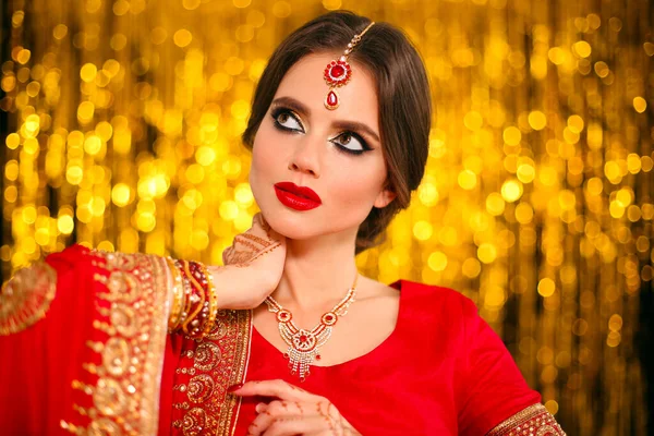 黄金のボケに赤いブライダルサリで美しいインドの女の子の肖像画 Kundanジュエリーと若いHindu女性モデル 伝統的なインドの衣装Lehenga Choli ヘンナ ペインティング花嫁の手にメヘンディ — ストック写真