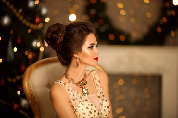 雅致女子的华丽肖像 具有婚纱风格和妆容 漂亮的黑发女孩 穿着舞会礼服 穿着金色珠宝 坐在现代椅子上 坐在灯火通明的圣诞装饰品上 — 图库照片
