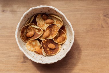 Küçük krep gevrekleri karantinaya alındı. Kahvaltıda evde fındık ve tereyağlı tatlı var. Ahşap bir masa arkasında ev yapımı ızgara yemek. Metin için Mini Üst Görünüm 