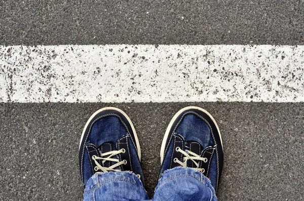 白いラインは、ステップとアスファルトの道路トップ ビューの男性靴 — ストック写真