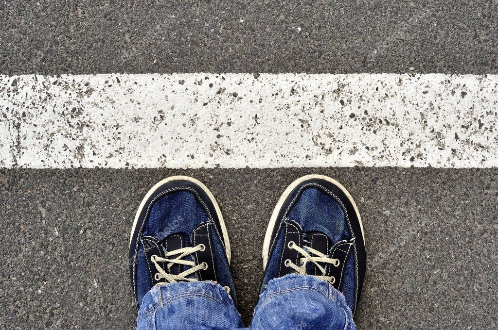 Top View of Male shoes on the asphalt road with white line, Step
