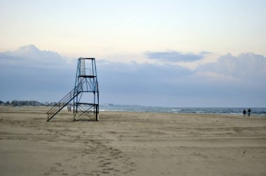 Bir fırtına sonra günbatımı sahilde cankurtaran kule.