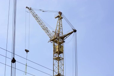 Mavi gökyüzünde inşaat sahasında kule vinç.