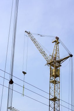 Mavi gökyüzünde inşaat sahasında kule vinç.