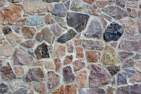 Texture Old brick or stone wall made of cobblestones background.