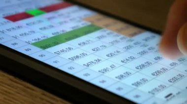 El (parmak) telefon ekranı ile çalışır. Finansal ve ekonomik tablolarla çalışmak. Kavram. Masa, finans, para. Makro görünümü kapat.
