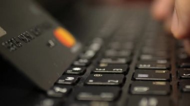 Laptop klavyesinde siyah platin kredi kartıyla ödeme, süper clouse-up, makro. 