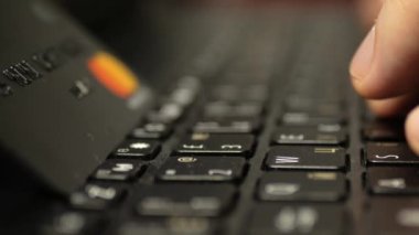 Laptop klavyesinde siyah platin kredi kartıyla ödeme, süper clouse-up, makro. 