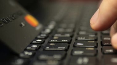 Laptop klavyesinde siyah platin kredi kartıyla ödeme, süper clouse-up, makro. 