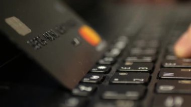 Laptop klavyesinde siyah platin kredi kartıyla ödeme, süper clouse-up, makro. 