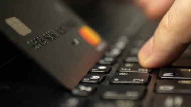 Laptop klavyesinde siyah platin kredi kartıyla ödeme, süper clouse-up, makro. 