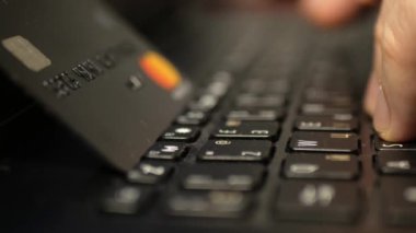 Laptop klavyesinde siyah platin kredi kartıyla ödeme, süper clouse-up, makro. 