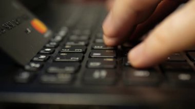 Laptop klavyesinde siyah platin kredi kartıyla ödeme, süper clouse-up, makro. 