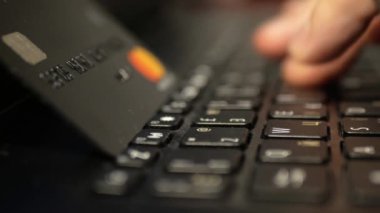 Laptop klavyesinde siyah platin kredi kartıyla ödeme, süper clouse-up, makro. 